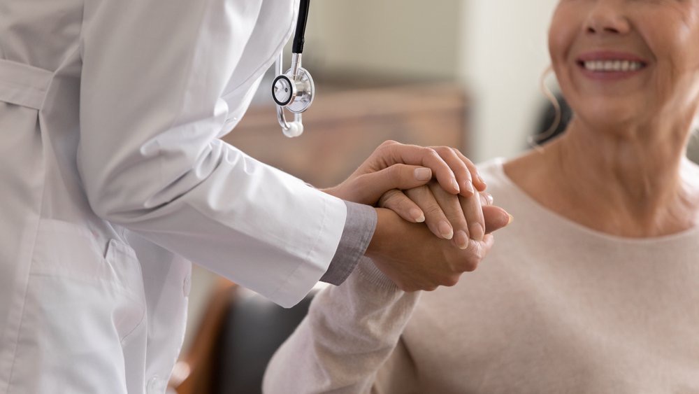 A physician holding a patient's hand