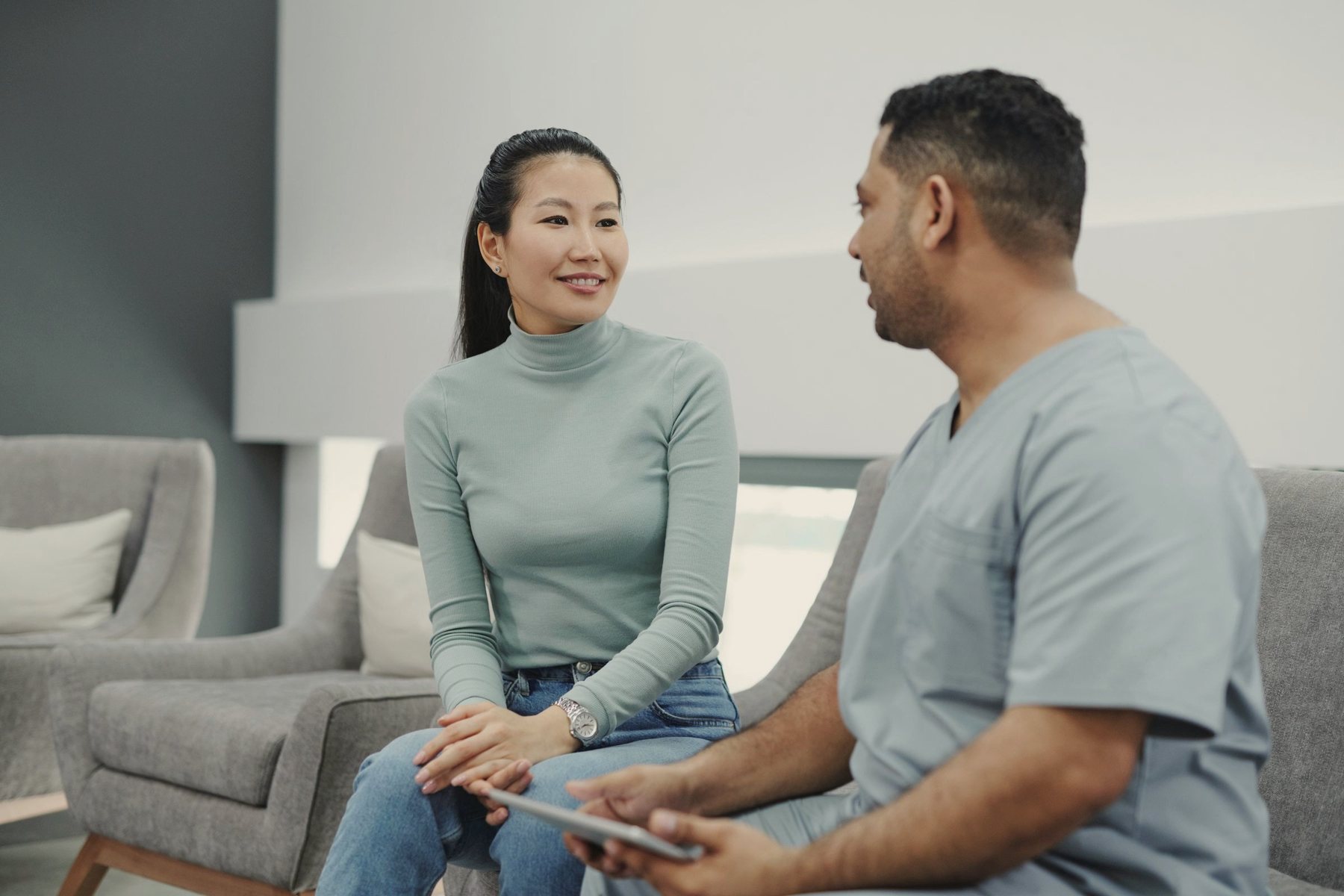 A patient and clinician talking in a bright waiting area